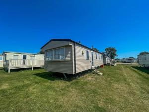 a tiny house sitting in a field of grass at Lovely 6 Berth Caravan At Valley Farm Park In Essex Ref 46762v in Great Clacton