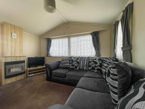 a living room with a couch and a tv at Lovely 6 Berth Caravan At Valley Farm Park In Essex Ref 46762v in Great Clacton