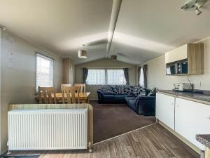 a living room and kitchen with a couch and a table at Lovely 6 Berth Caravan At Valley Farm Park In Essex Ref 46762v in Great Clacton