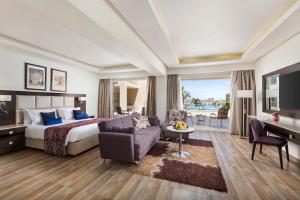 a hotel room with a bed and a couch and a desk at Pickalbatros White Beach Resort - Hurghada in Hurghada