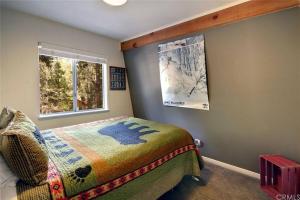 1 dormitorio con cama y ventana en Cozy Mountain Retreat with Private Jacuzzi, en Big Bear Lake