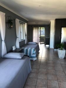 a bedroom with two beds and a tile floor at Knysna Lagoon View in Knysna