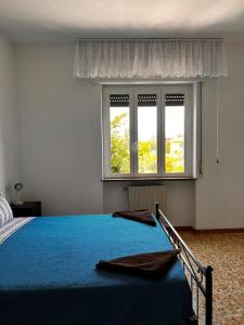 a bedroom with a blue bed and a window at Camere Giulia in Bergamo