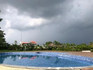 una gran piscina frente a una casa en Beyond The Corbett Tales Resort and Spa en Rāmnagar