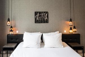ein Schlafzimmer mit einem Bett mit weißen Kissen in der Unterkunft Weber Hotel 397 in Amsterdam
