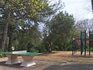 a ping pong table in a park with a playground at Auberge de Jeunesse HI Nîmes in Nîmes