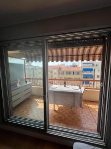 uma vista a partir de uma janela de uma varanda com uma mesa em Beautiful Arty Apartment em Nice