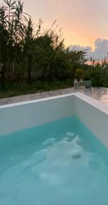a swimming pool with a sunset in the background at Casello 79 Rais in Finale