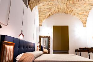 a bedroom with a blue bed and a mirror at La Rua in Ascoli Piceno