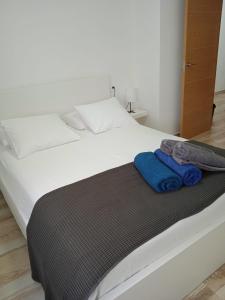 un letto bianco con due asciugamani blu sopra di Blue View Hermoso Apartamento Remodelado Ubicación Ideal a Costa Teguise