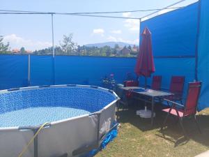 een zwembad met een tafel en stoelen en een parasol bij Saray Bosna Home in Gladno Polje