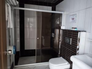uma casa de banho com um chuveiro, um WC e um lavatório. em LÜKS HOTEL em Mersin