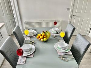 a dining table with a bowl of fruit on it at Cheerful 3-bedroom Near Bikepark Wales Merthyr Tydfil Town Centre in Merthyr Tydfil