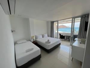 Un dormitorio con dos camas y vista al mar. en La Ballena Azul Hotel, en Taganga 38 fotos más