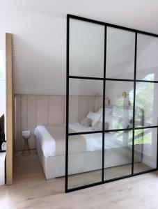 Schlafzimmer mit einem Bett und einer Glaswand in der Unterkunft Sen Nad Jeziorakiem in Siemiany