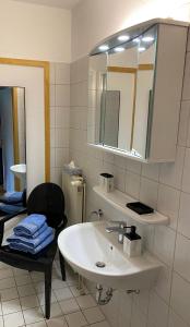 a bathroom with a sink and a mirror and a chair at Helpens Hof in Salzhausen +33 photos