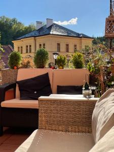 ławka na balkonie z domem w tle w obiekcie Pension & Restaurant Atmosféra w mieście Loket