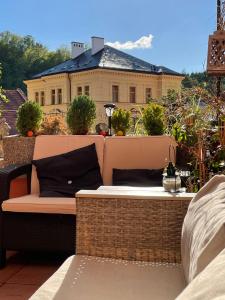 a bench on a balcony with a house in the background at Atmosféra Rooms & Restaurant in Loket
