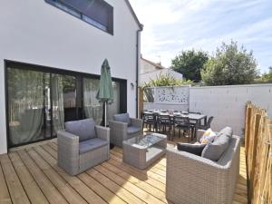 un patio avec des chaises et une table sur une terrasse dans l'établissement Maison avec jardin 15 min hyper centre Nantes, à Orvault