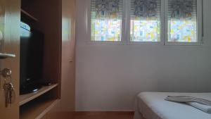 sypialnia z witrażami i łóżkiem w obiekcie El Colmenar Habitaciones w Madrycie