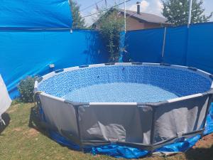een hot tub in een achtertuin met een blauw hek bij Saray Bosna Home in Gladno Polje