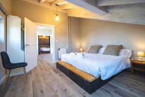 a bedroom with a large white bed and a chair at Las Cerezas Gozón By Silastur in Luanco