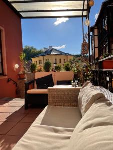 a patio with a couch sitting on a balcony at Pension & Restaurant Atmosféra in Loket