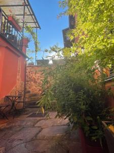 a stone wall next to a building with a tree at Pension & Restaurant Atmosféra in Loket