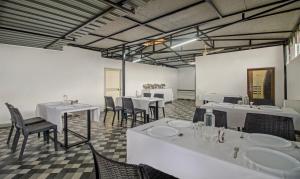uma sala de jantar com mesas e cadeiras brancas em Treebo Trend Tulip Comfort em Pune