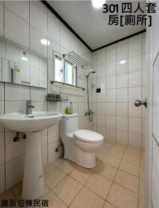 uma casa de banho com um lavatório e um WC em 維辰包棟民宿Wei Chen Resort B&B em Xiaoliuqiu