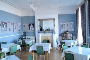 a dining room with blue walls and tables and a fireplace at The Lawrence of Arabia Hotel in Weymouth