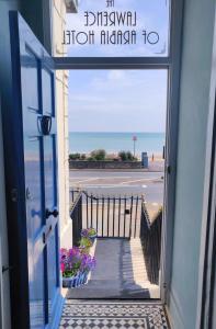 an open door with a view of the beach at The Lawrence of Arabia Hotel in Weymouth