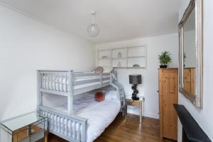 a bedroom with a white bunk bed with a ladder at Warm and Spacious Smart Stay - Close to Harry Potter World and mainline station connecting to London and Luton Airport - Contractors and corporate bookings welcome in St. Albans