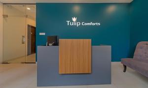 a reception desk in a lobby with a tupperware sign on a wall at Treebo Trend Tulip Comfort in Pune