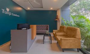 a waiting room with a couch and a tv at Treebo Trend Tulip Comfort in Pune