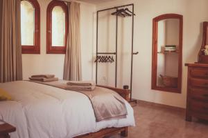 a bedroom with a bed and a dresser and windows at Ca la Tendeta in Tivissa