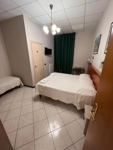 Shelter Affittacamere في جينوا: غرفة نوم بسرير وستارة خضراء