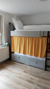 a bedroom with a bunk bed with an orange curtain at Hostel Balingen in Balingen