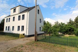 una casa blanca con una valla delante en Landhaus Oderbruch, en Bad Freienwalde