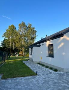 een wit huis met een patio en een tuin bij Domy na polanie-Szafirek in Polanica-Zdrój