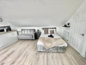 1 dormitorio con 1 cama y 1 sofá en Exec 1-Bedroom Studio Apartment Briton Ferry, Neath Port Talbot 5, en Briton Ferry