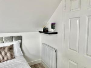 1 dormitorio con cama y pared blanca con puerta en Exec 1-Bedroom Studio Apartment Briton Ferry, Neath Port Talbot 5, en Briton Ferry