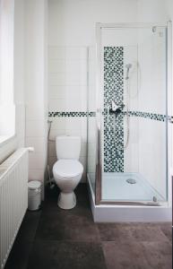 a bathroom with a toilet and a glass shower at Die Jute Stube in Bad Freienwalde