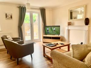 uma sala de estar com um sofá e uma televisão em Cosy 2-Bedroom Cottages in Central Windsor em Windsor