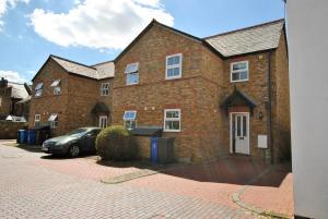 a brick building with a car parked in front of it at Garfield Place Cosy 2-Bedroom Cottage Central Windsor with Parking in Windsor