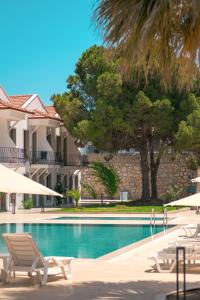 達特恰的住宿－Feri Surf Club Hotel Datça，一个带躺椅和遮阳伞的游泳池