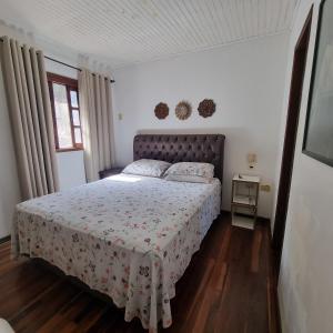 um quarto com uma cama com colcha floral em COYOTE POUSADA&HOSTEL em Foz do Iguaçu