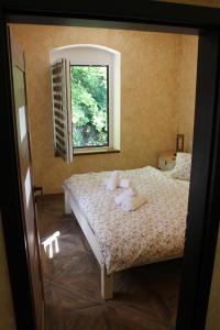 ein Schlafzimmer mit einem Bett mit Kissen und einem Fenster in der Unterkunft Hrad Vildstejn in Skalná