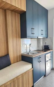 a small kitchen with blue cabinets and a sink at Chilies Rizes in Nafpaktos