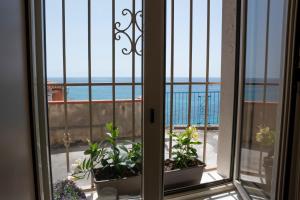 a window with a view of the ocean at BelMa' Aparthotel and Rooms in Marina di Camerota
